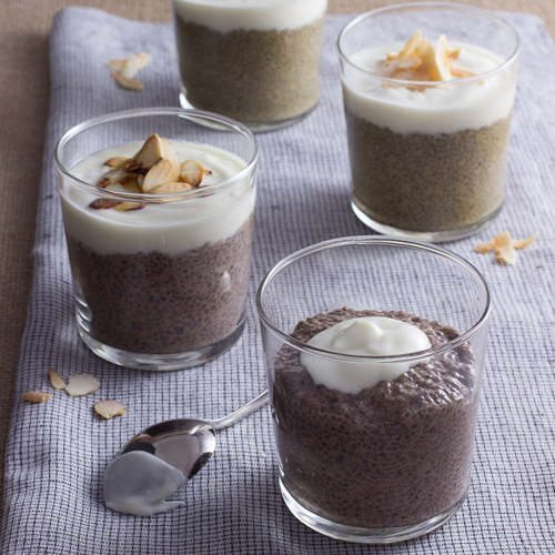 Four versions of Chia pudding on a blue and white gingham napkin.