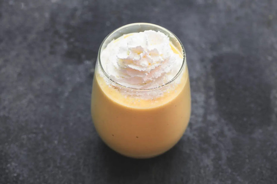 glass or orange pumpkin nog, with a peak of whipped cream on top.