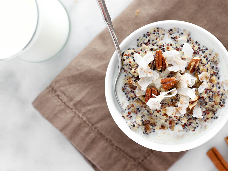 white pudding with chia seeds, and flaked coconuts with almonds in a white bowl